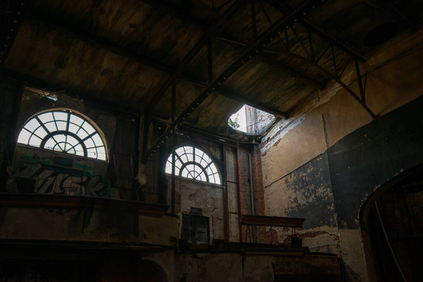 Duas grandes janelas em um teatro abandonado deixando a luz brilhar na sala - Foto, Imagem