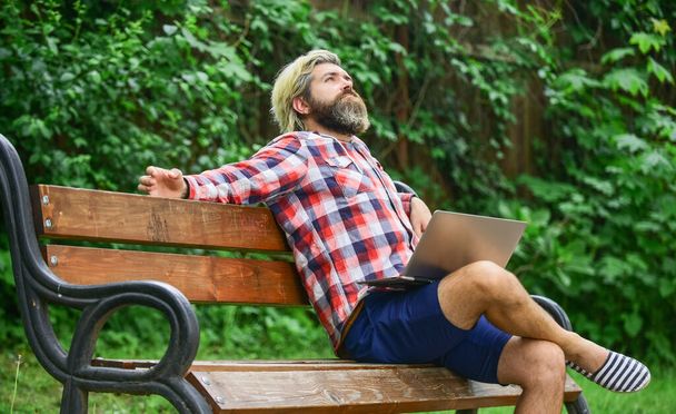 Hipster inspired work in park. Modern laptop. Remote job. Fresh air. Mobile internet. Online shopping. Agile business. Bearded guy sit bench park nature background. Work and relax. Working online - Foto, afbeelding