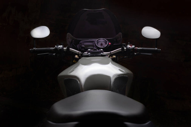Мотоцикл Caferacer на темном фоне с включенными фарами. - Фото, изображение