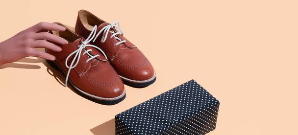 Fake-Hand und Vintage-Schuhe auf beigem Hintergrund. Modekonzept. Stillleben isometrisches minimales Design - Foto, Bild