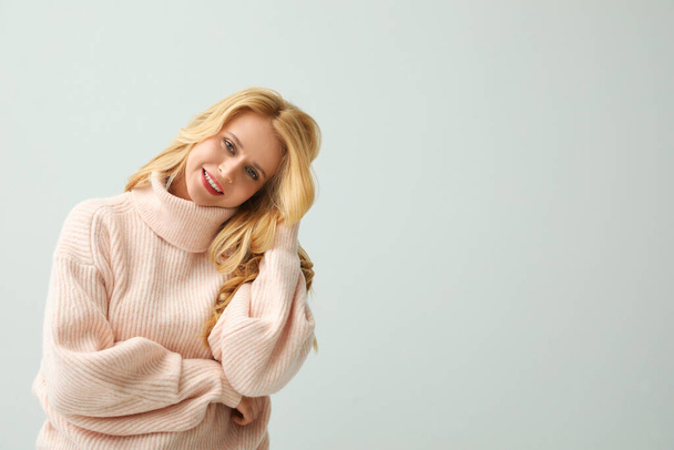 白い背景に暖かいピンクのセーターを着た美しい若い女性。テキストのスペース - 写真・画像