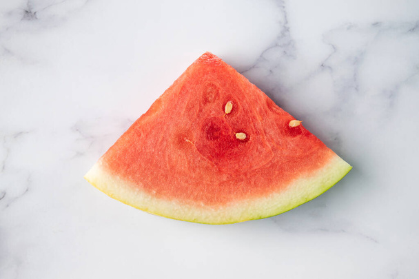 aufgeschnittene Wassermelonenfrucht auf grauem und weißem Marmorhintergrund - Foto, Bild
