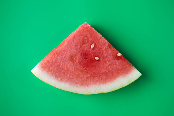 szeletelt görögdinnye gyümölcs ül a zöld háttér - Fotó, kép