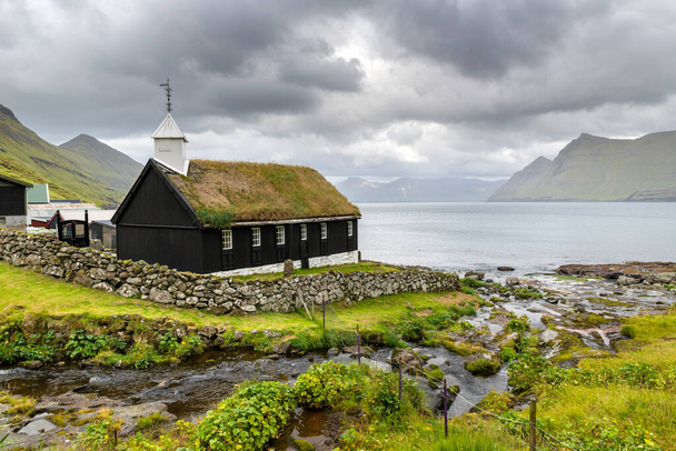 Pequeña iglesia de madera negra en el pueblo de Funningur, Islas Feroe, Dinamarca - Foto, imagen