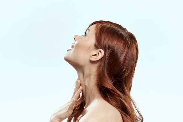 Όμορφη γυναίκα κρατώντας τα μαλλιά χαμόγελο καλλυντικά lifestyle γυμνοί ώμοι hairstyle φροντίδα γοητεία φως φόντο - Φωτογραφία, εικόνα