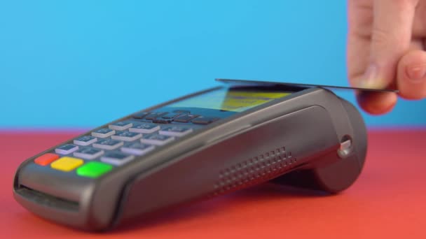 Paiement sans contact avec carte de crédit et terminal en gros plan sur fond couleur - Séquence, vidéo