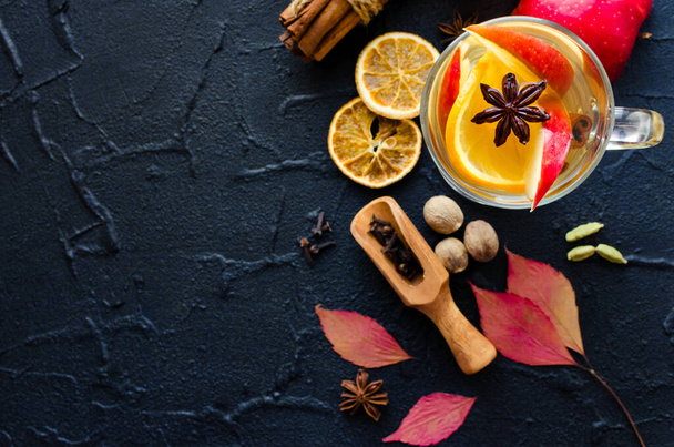Autumn mulled wine based on white wine with orange, apple and spices cinnamon sticks, star anise, nutmeg, cardamom and clove on black background. Seasonal beverages recipe. Top view. Copy space. - Fotoğraf, Görsel