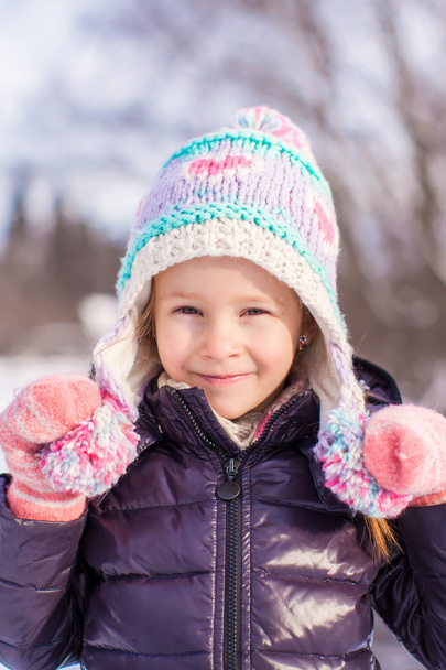 Portrait of little adorable girl in winter hat at snowy forest - Photo, Image