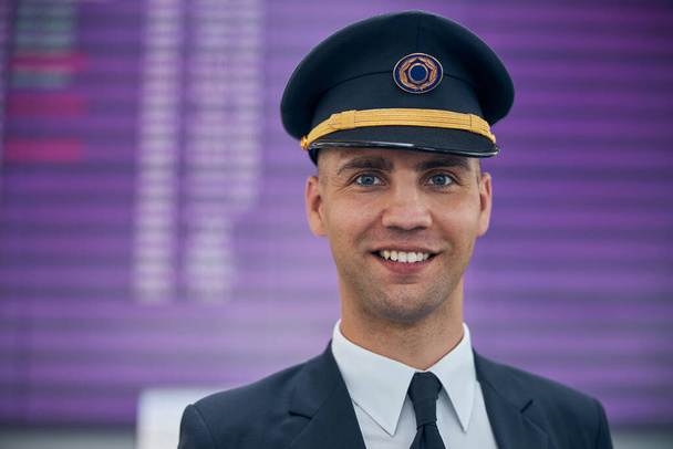 Vidám férfi pilóta áll a repülőtér terminál - Fotó, kép