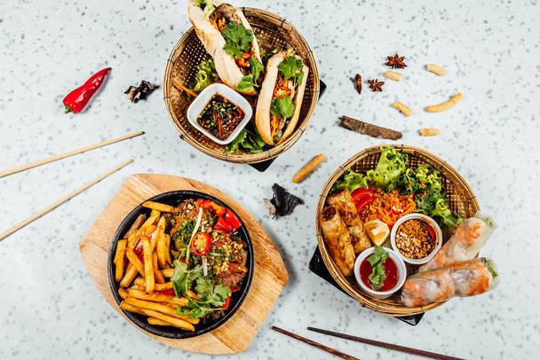 Fresh and delicius Vietnamese food table, Pho ga, pho bowls, noodles, spring rolls, asian dinner table on bright background - Foto, imagen