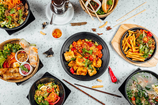 Čerstvé a lahodné vietnamské jídelní stůl, Pho ga, pho misky, nudle, jarní závitky, asijský jídelní stůl na jasném pozadí - Fotografie, Obrázek