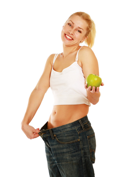 Young girl with big jeans and apple - Foto, Imagen