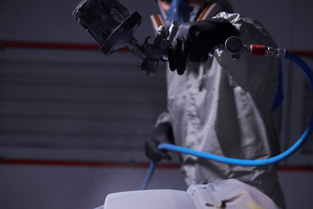 close-up photo of male hands applying painting machine equipment on car surface - Foto, Bild