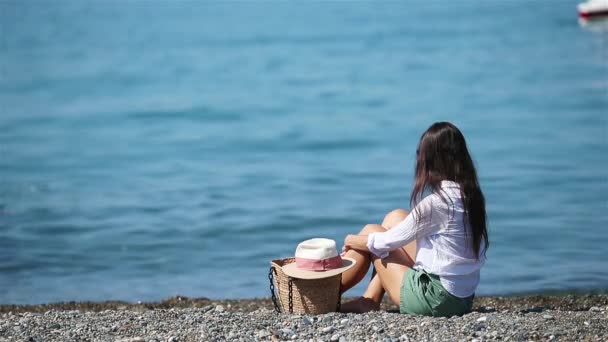 Nuori kaunis nainen rentoutua rannalla - Materiaali, video