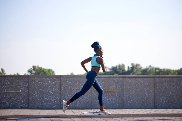 slim athlete female runs in city - Фото, зображення