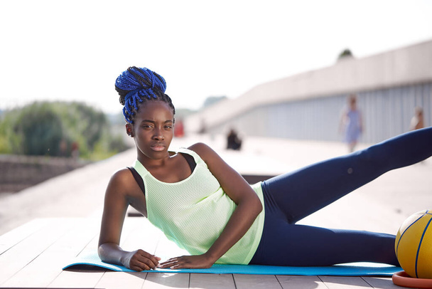 beautiful sporty woman do exercises on mat outdoors - Zdjęcie, obraz