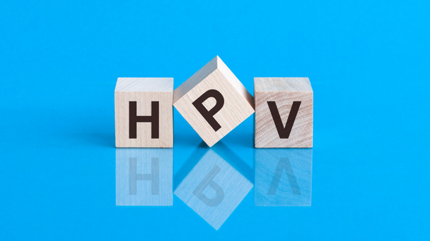 HPV -ヒトパピローマウイルス、ブロック上に書かれた単語。Humani Papilloma青い背景にウイルスの碑文。医療ウイルスの概念. - 写真・画像
