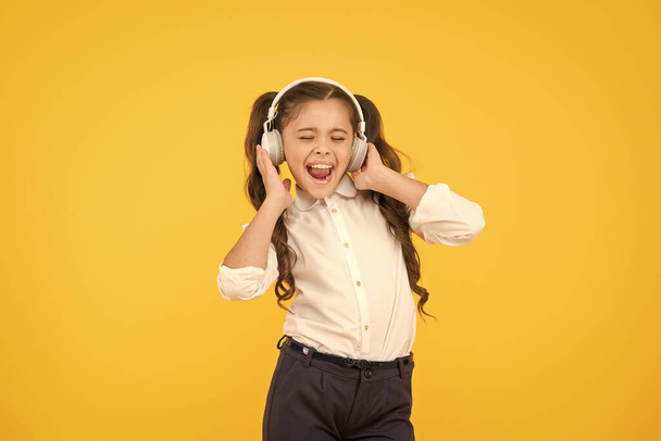 Child enjoy music sound. Audio schooling. Home schooling. Small girl pupil headphones. Child happy listen music. Audio book. Education and fun concept. Online schooling. Listening lesson. Sing song - Photo, image