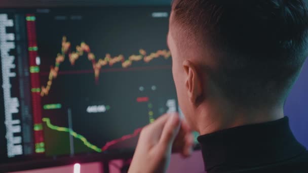 Огляд Stockbroker працює над глобальною стратегією аналізу фінансової торгівлі на комп'ютері в нічному офісі в неоновому світлі.. - Кадри, відео