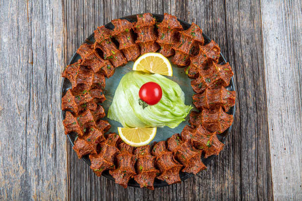 Παραδοσιακό τουρκικό ορεκτικό Cigkofte με lavash, συστατικά είναι ωμά, πλιγούρι κρέατος, κρεμμύδι, πελτέ ντομάτας, καυτερή πιπεριά και αλάτι. Τουρκική τοπική ιδέα ακατέργαστων τροφίμων. - Φωτογραφία, εικόνα