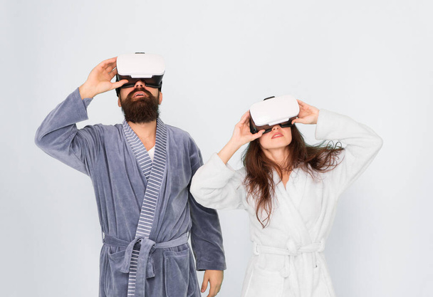 morning start with future technology. digital couple. innovation in family relations. create your reality. New world of virtual reality. family couple wear vr headset. girl and man relax in bathrobe - Photo, image