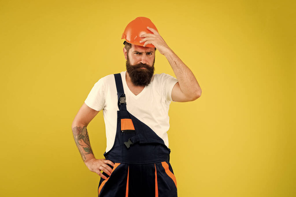 Home Design and Renovation Trends. Engineer builder uniform. Man builder hard hat. Creativity and practice. Improvement and renovation. Brutal man builder. Bearded guy worker on yellow background - Valokuva, kuva