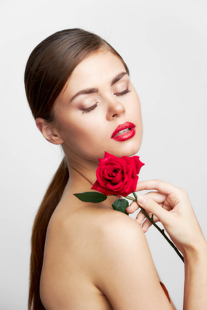 Brunette with bare shoulders Eyes closed flower charm red lips  - Фото, зображення