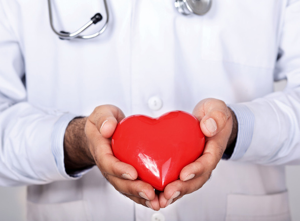 mannelijke arts met een stethoscoop houden hart - Foto, afbeelding