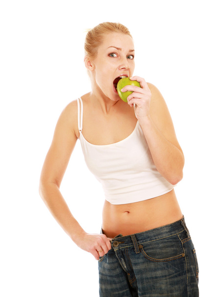 junges Mädchen mit großen Jeans und Apfel - Foto, Bild
