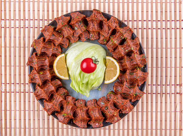 Παραδοσιακό τουρκικό ορεκτικό Cigkofte με lavash, συστατικά είναι ωμά, πλιγούρι κρέατος, κρεμμύδι, πελτέ ντομάτας, καυτερή πιπεριά και αλάτι. Τουρκική τοπική ιδέα ακατέργαστων τροφίμων. - Φωτογραφία, εικόνα