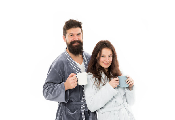 Caffeine power concept. Couple enjoy lazy weekend and drink coffee. Wife and husband bathrobes hold tea mug coffee cup. With coffee morning tastes better. Couple relax in morning with coffee - Фото, изображение