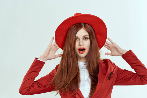 όμορφη γυναίκα σε κόκκινο καπέλο σακάκι μακιγιάζ κομψό στυλ φως στούντιο φόντο - Φωτογραφία, εικόνα