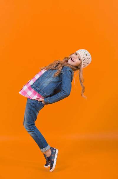 Child in jeans suit, hat, plaid shirt balance tiptoe - Zdjęcie, obraz