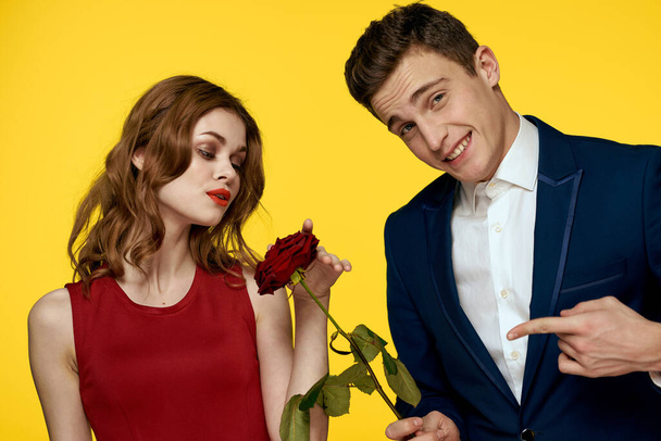 Young charming couple rose relationship romance gift as a lifestyle yellow isolated background - Фото, изображение