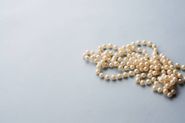 Perle di perle su sfondo grigio decorazione vista dall'alto - Foto, immagini