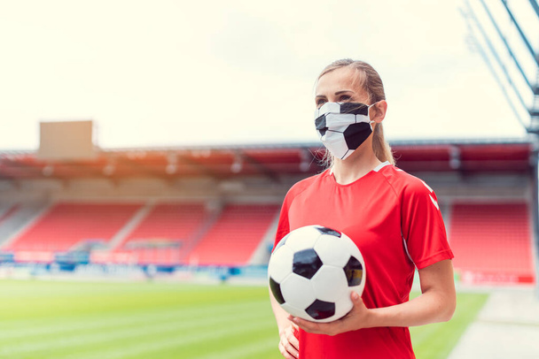 Žena fotbalista na obličeji maska na prázdném stadionu - Fotografie, Obrázek