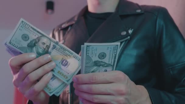 Primer plano de los delincuentes masculinos mano contando dinero en el fondo de luces de neón de un club nocturno. - Metraje, vídeo