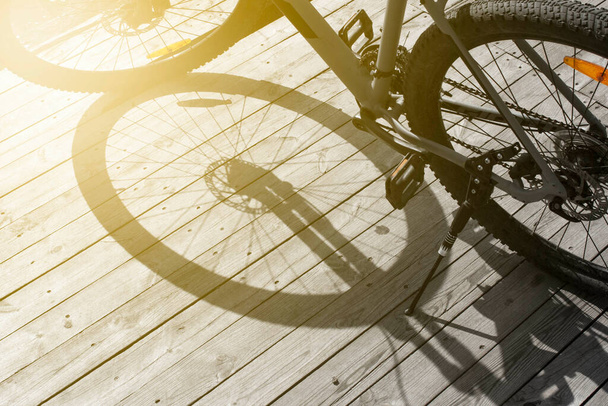 тень велосипеда на старой текстуре дерева, передний и задний фон размыты с эффектом боке - Фото, изображение