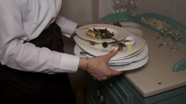 Официантка забирает много грязных тарелок после банкета.. - Кадры, видео