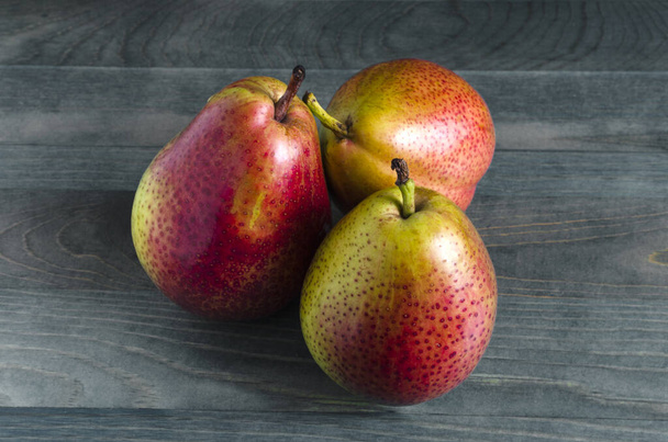 three ripe pears on a wooden background close up - Foto, Imagen