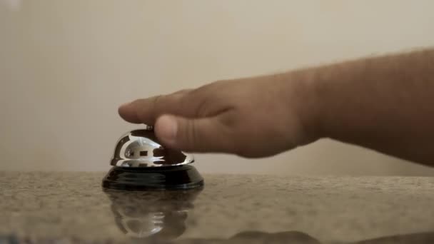 Close-up of a man pressing a bell in a hotel. a girl in a white shirt approaches the reception Desk. Service, hotel concept.  - Footage, Video