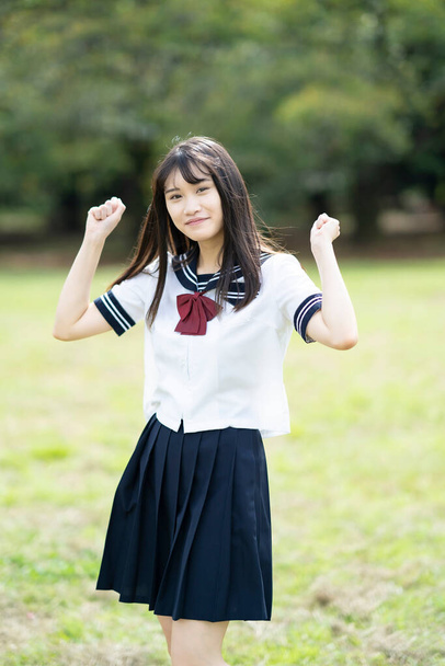 Una estudiante de secundaria posando apoyando con una sonrisa al aire libre - Foto, Imagen