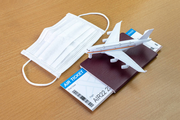 Travel during the covid-19 pandemic. airplane model with face mask, air ticket and passport. ready for holidays. - Fotoğraf, Görsel