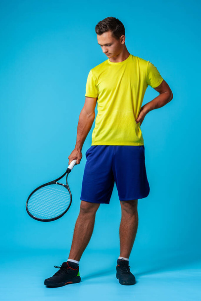Full length studio portrait of a tennis player man on blue background - Foto, imagen