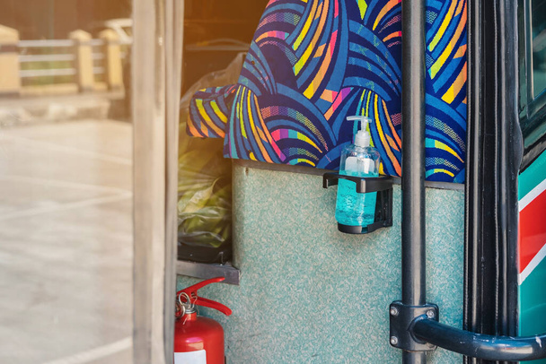 Kék alkoholos gél palack lóg az ajtón a emeletes busz szolgálja az utasok és megakadályozzák a Corona vírus (Covid-19) terjedését. Utazz biztonságosan tömegközlekedéssel. Új normális életmód. - Fotó, kép