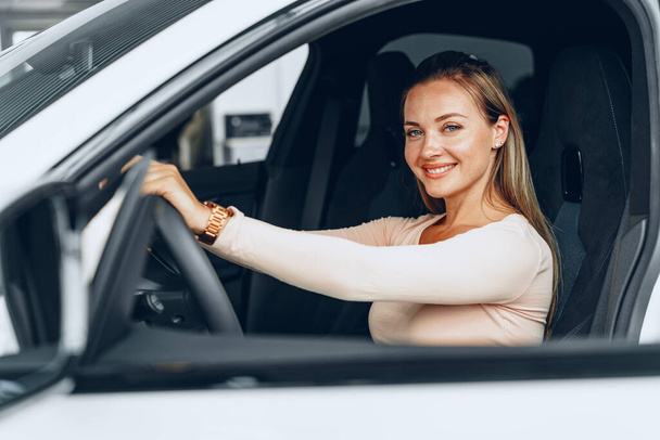 Young attractive caucasian woman sits in her newly bought car - Photo, Image