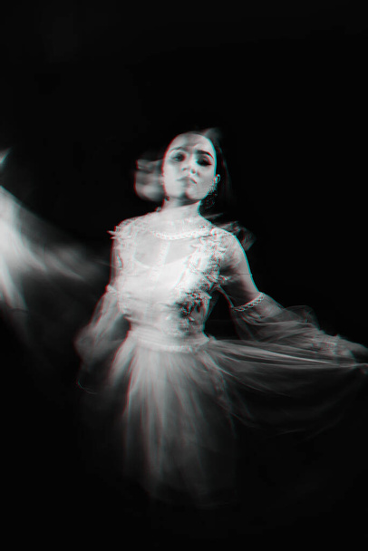 αφηρημένο πορτρέτο ενός κοριτσιού φάντασμα σε λευκό φόρεμα σε σκούρο φόντο με θολή - Φωτογραφία, εικόνα