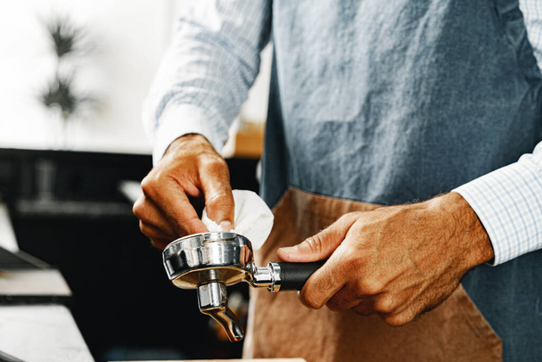Unrecognizable man barista preparing coffee on professional coffee machine - Foto, Bild