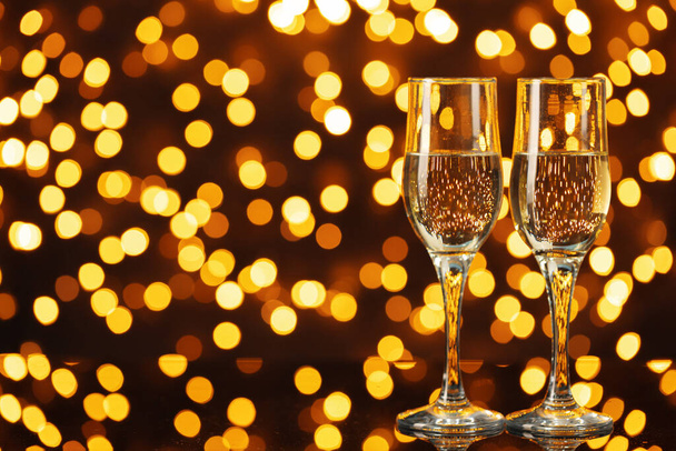 Two glasses of Champagne against bokeh lights background - Фото, изображение