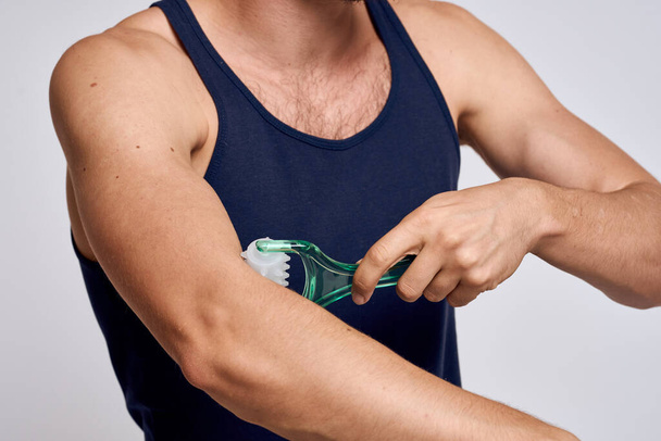 férfi masszírozó a kezében, és egy kék póló spa kezelések higiénia tiszta bőr érzelmek modell - Fotó, kép